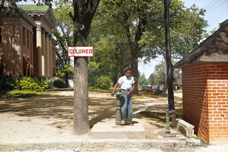 Latin America Property - A young African American boy drinks out of a fountain labeled 'Colored'