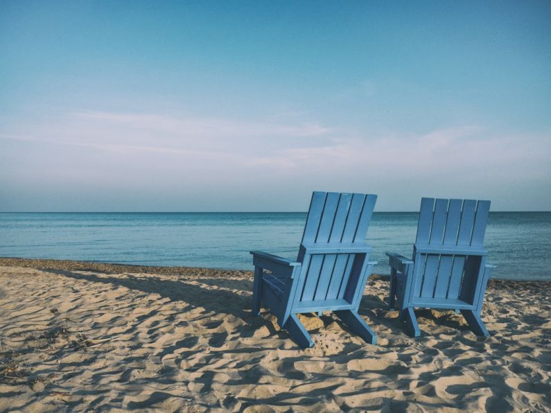 Retirement Beach - two blue beach chairs near body of water