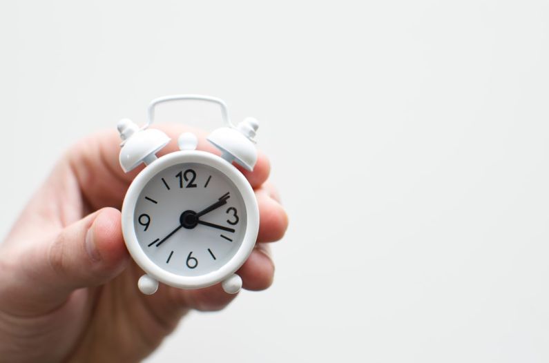First-time Buyer - person holding white mini bell alarmclock