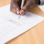 Contract Document - person writing on white paper