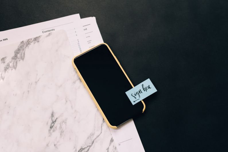 Tax Document - black smartphone on white pad