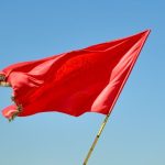 Red Flag - red flag on pole under blue sky during daytime