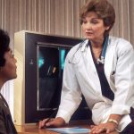 Tenant Screening - doctor sitting on desk talking to sitting woman