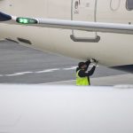 Emergency Repair - a man in a safety vest standing next to an airplane