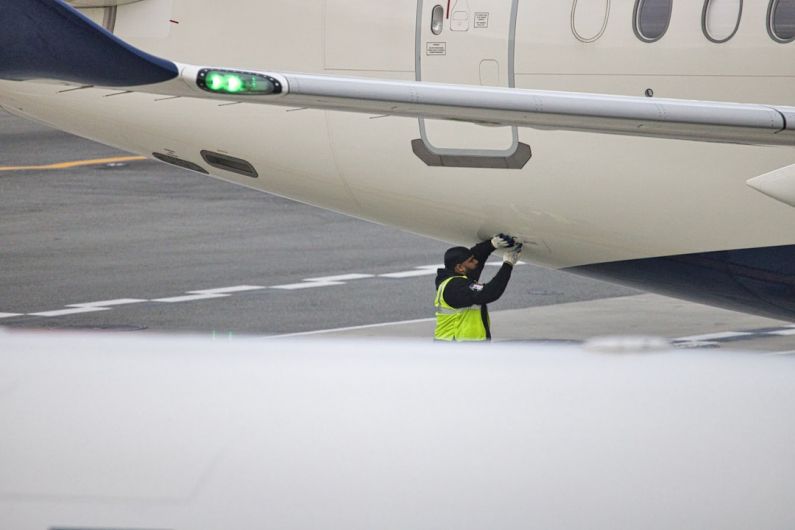 Emergency Repair - a man in a safety vest standing next to an airplane