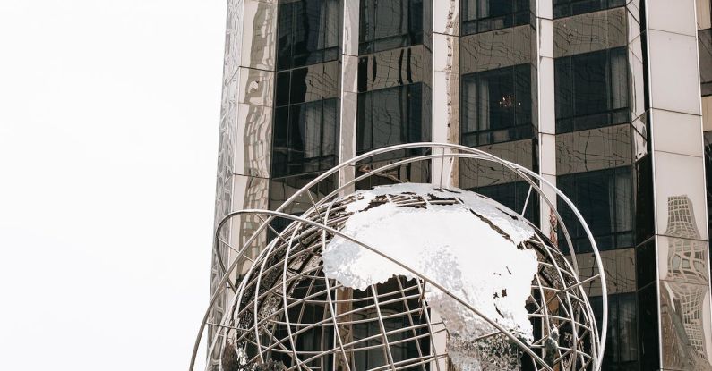 Globe Finance - Landmark sculpture Columbus Circle globe installed outside modern skyscraper in Manhattan New York City