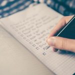Strategy Planning - person writing bucket list on book