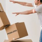 Difficult Tenant - Full body of young man in sneakers and jeans pushing and falling boxes saying Work Problems Anxiety Stress and Deadline while fighting with problems