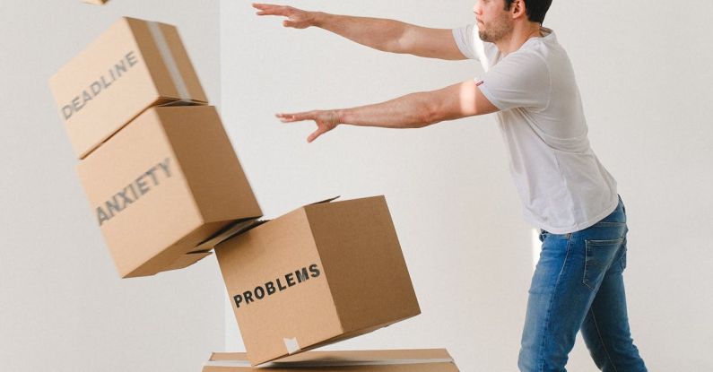 Difficult Tenant - Full body of young man in sneakers and jeans pushing and falling boxes saying Work Problems Anxiety Stress and Deadline while fighting with problems