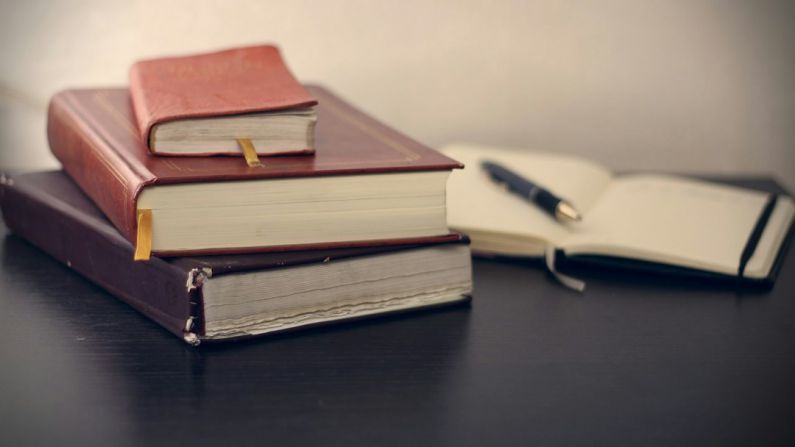 Law Book - selective focus photography of three books beside opened notebook
