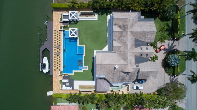 Drones Real Estate - bird's eye view of house with pool near body of water