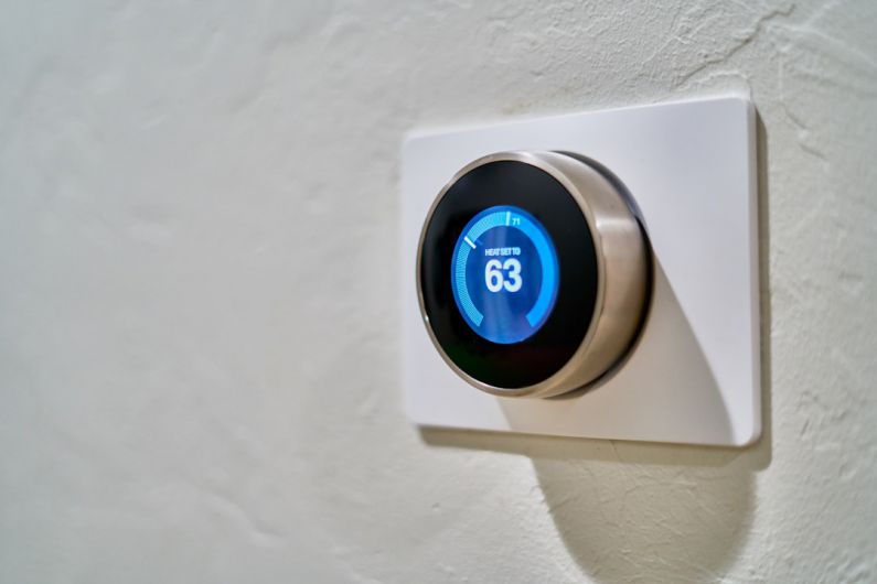 IoT Home - gray Nest thermostat displaying at 63