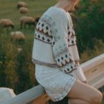 Language Barrier - A Woman Leaning against a Barrier Separating the Road from a Pasture