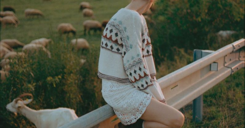Language Barrier - A Woman Leaning against a Barrier Separating the Road from a Pasture