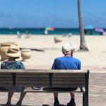 Retirement Beach - Man and Woman Sitting on Brown Wooden Bench