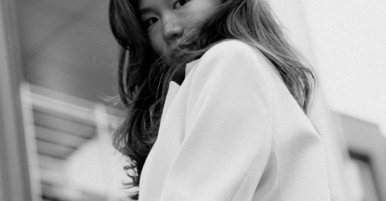Portfolio Building - A woman in a white coat standing on a balcony