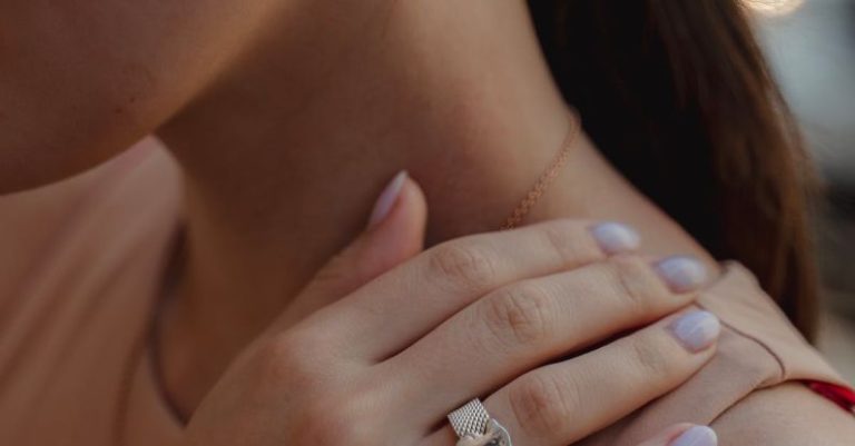 Lowball Offer - Crop woman with gold earings demonstrating hand with manicure and precious ring on ring finger