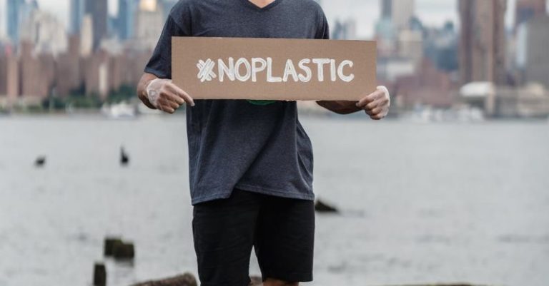 Pet Policy - Man in Black Crew Neck T-shirt Holding the Beach Signage