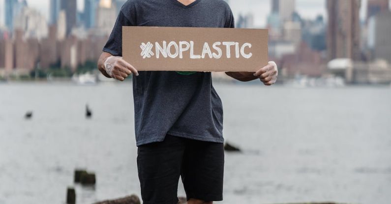 Pet Policy - Man in Black Crew Neck T-shirt Holding the Beach Signage