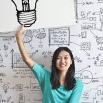 REIT Graph - Woman Draw a Light bulb in White Board