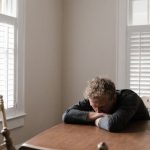 Distressed Home - Man in Gray Long Sleeve Shirt Sitting on Brown Wooden Chair