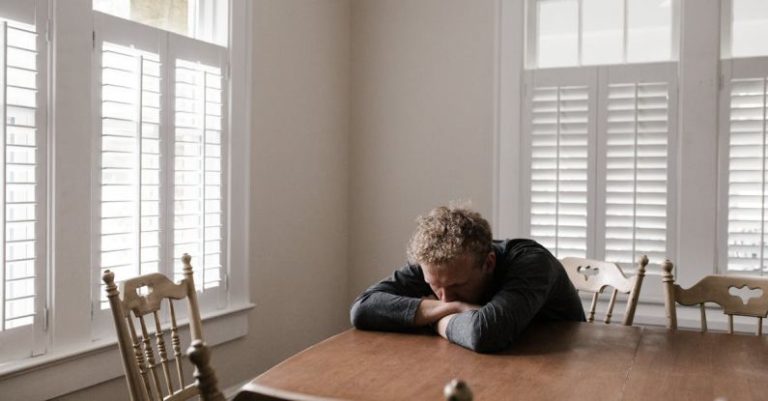 Distressed Home - Man in Gray Long Sleeve Shirt Sitting on Brown Wooden Chair