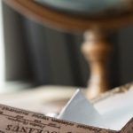 International Home - Paper boat made of world map placed on brown wooden table near round globe with continents in light room at home