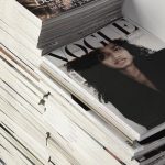 Commercial Trend - High angle many fashion magazines stacked on floor against white brick wall in studio