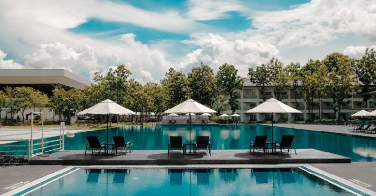 Luxury Villa - Black Outdoor Lounge Chair in Between Blue Swimming Pool Under White Cloudy Blue Sky