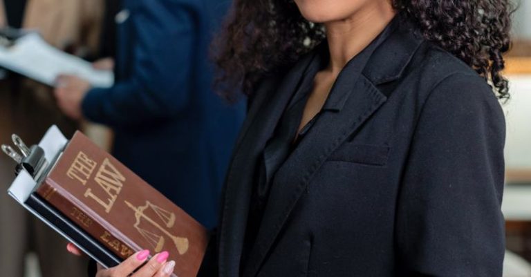 Law Book - A Woman in Black Blazer Holding a Law Book